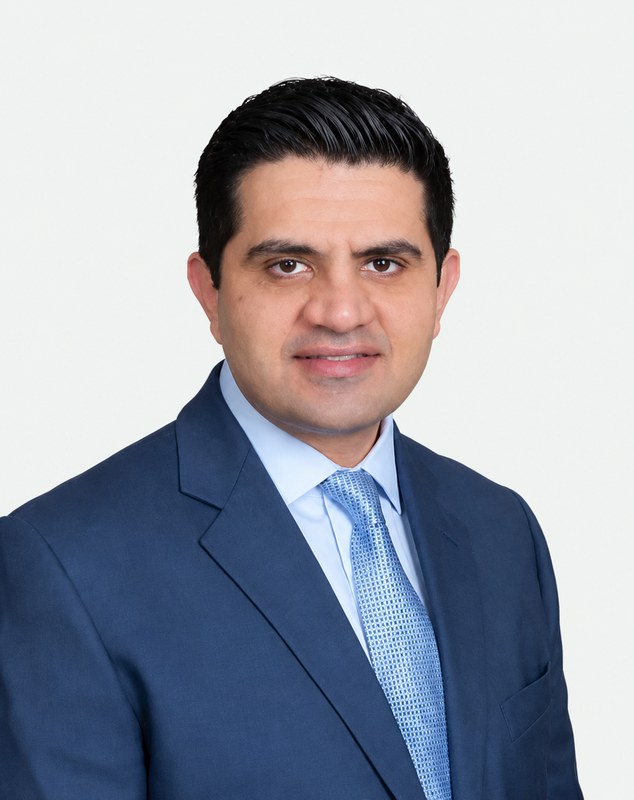 Dr. Ron Malakpour, DDS, MS, smiling in a blue suit